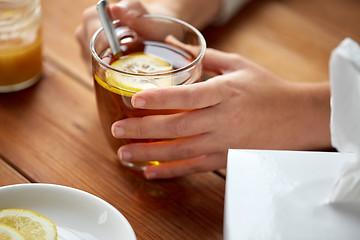 Image showing close up of ill woman drinking tea with lemon