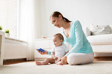 Image showing happy mother showing smartphone to baby at home