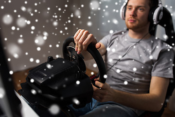 Image showing man playing car racing video game at home