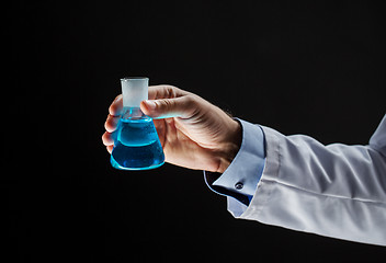 Image showing close up of scientist holding flask with chemical