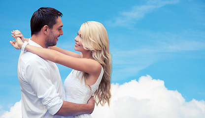 Image showing happy couple hugging over blue sky and cloud