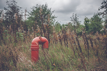 Image showing Red pipeline on a rural meadow