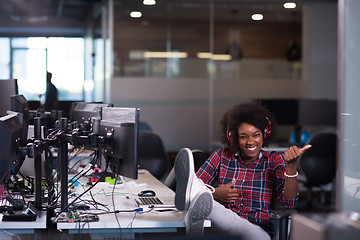 Image showing woman at her workplace in startup business office listening musi