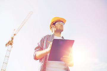 Image showing builder in hardhat with clipboard outdoors