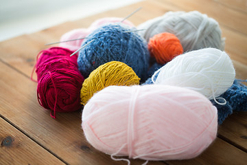 Image showing knitting needles and balls of yarn on wood