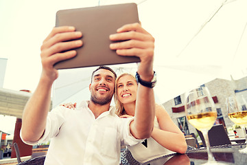 Image showing happy couple taking selfie with tablet pc at cafe