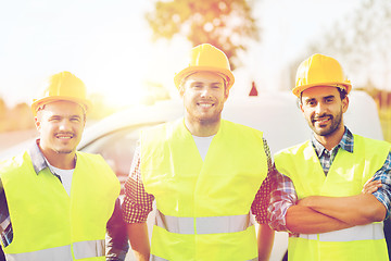 Image showing group of smiling builders in hardhats outdoors