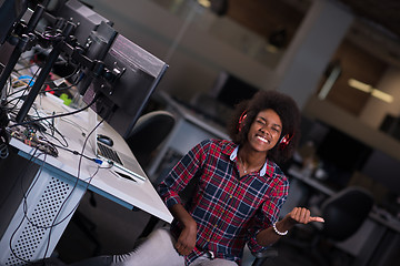 Image showing woman at her workplace in startup business office listening musi