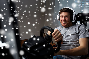 Image showing man playing car racing video game at home