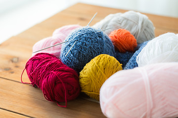 Image showing knitting needles and balls of yarn on wood