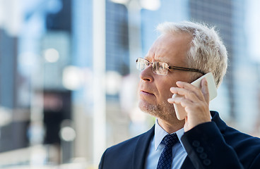 Image showing senior businessman calling on smartphone in city