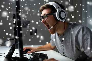 Image showing man in headset playing computer video game at home