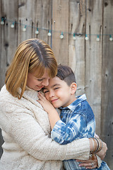 Image showing Mother and Mixed Race Son Hug Near Fence