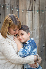 Image showing Mother and Mixed Race Son Hug Near Fence