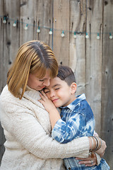 Image showing Mother and Mixed Race Son Hug Near Fence