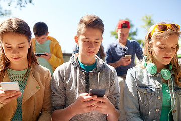 Image showing group of teenage friends with smartphones outdoors