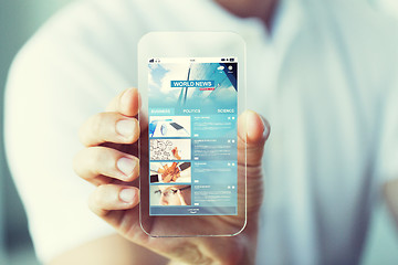 Image showing close up of hand with business news on smartphone