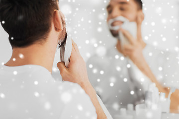 Image showing close up of man removing shaving foam from face