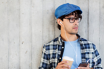 Image showing man with earphones and smartphone drinking coffee