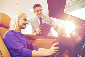 Image showing happy woman with car dealer in auto show or salon