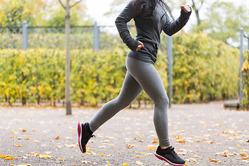 Image showing close up of young woman running in autumn park