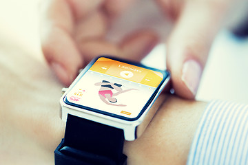 Image showing close up of hands setting sport app on smartwatch