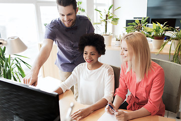 Image showing happy creative team with computer in office