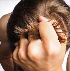 Image showing Closeup of hand pulling hair from head of a male person