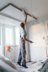 Image showing Plasterer renovating indoor walls and ceilings. Construction finishing works.