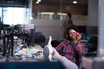 Image showing young woman at her office workplace playing with plane toy