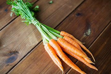 Image showing close up of carrot bunch on wooden table