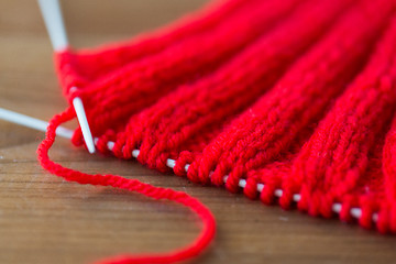 Image showing hand-knitted item with knitting needles on wood