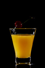 Image showing Cherry dropping into orange drink