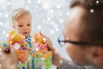 Image showing father and son playing with ball clay at home