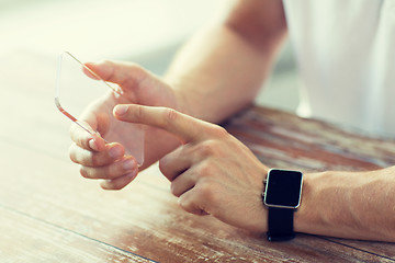 Image showing close up of hands with smart phone and watch