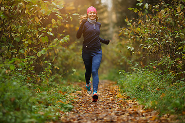 Image showing Blond girl running among trees