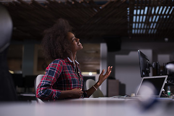 Image showing woman at her workplace in startup business office listening musi