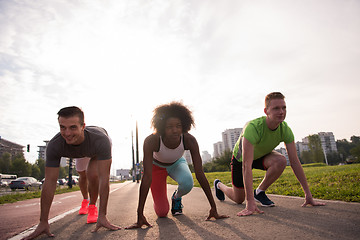 Image showing multiethnic group of people on start position for jogging