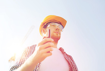 Image showing builder in hardhat with radio