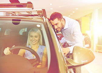 Image showing happy couple buying car in auto show or salon