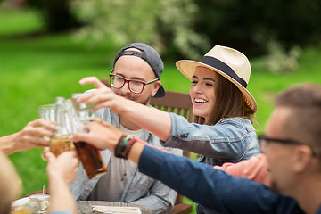 Image showing happy friends clinking glasses at summer garden