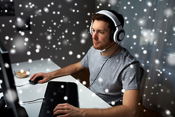 Image showing man in headset playing computer video game at home