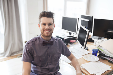 Image showing happy creative male office worker with computers