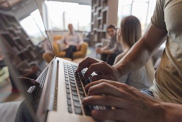 Image showing close up of male hands while working on laptop