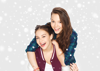 Image showing happy smiling teenage girls hugging over snow