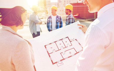 Image showing close up of architects with blueprint at building