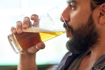 Image showing close up of man drinking beer at bar or pub