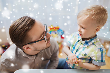 Image showing father and son playing with ball clay at home