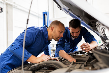 Image showing mechanic men with wrench repairing car at workshop