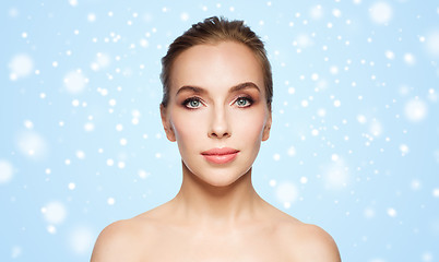 Image showing beautiful young woman face over snow